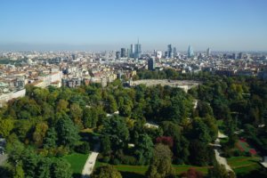 Luftaufnahme einer Stadt mit einem großen Park und einer modernen Skyline im Hintergrund.