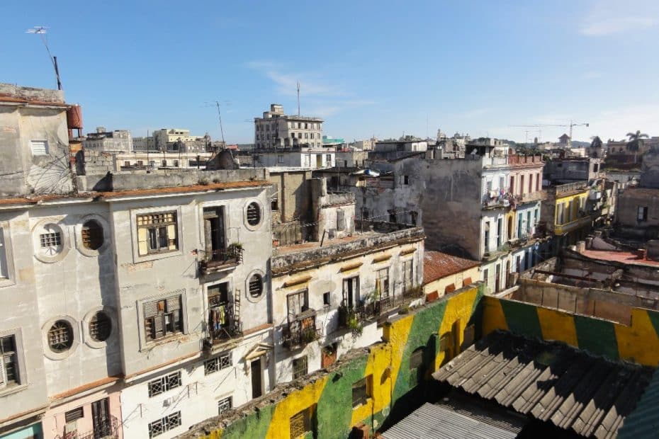 Blick auf eine Ansammlung von alten, farbenfrohen Gebäuden in Havanna, Kuba, mit Balkonen und Wäsche auf den Leinen.