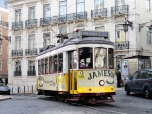 Eine Straßenbahn mit der Aufschrift 'Jameson' fährt durch eine Straße in Lissabon.