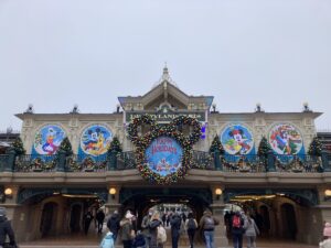 Eingang zu Disneyland Paris mit bunten Weihnachtsdekorationen und Figuren von Disney-Charakteren.