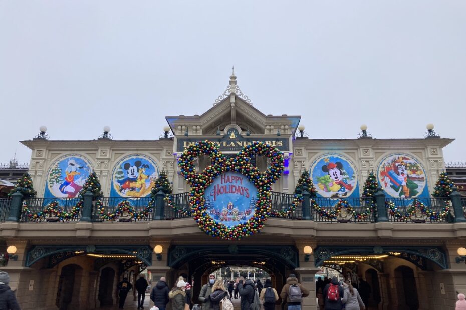 Eingang zu Disneyland Paris mit bunten Weihnachtsdekorationen und Figuren von Disney-Charakteren.