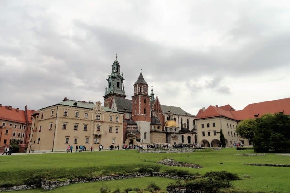Wawel Schloss in Krakau mit mehreren Gebäuden und einer grünen Fläche im Vordergrund.