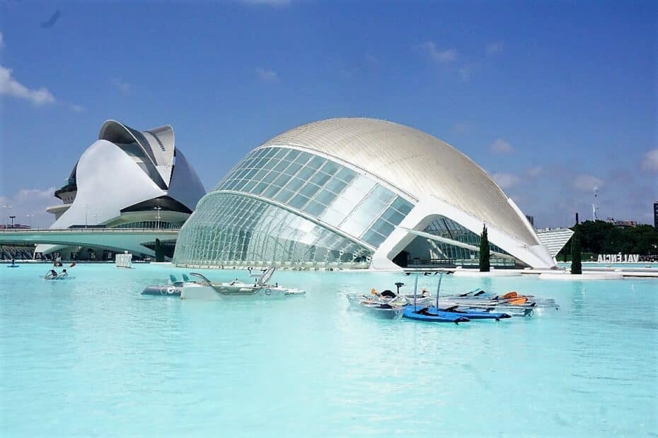 Zwei moderne Gebäude mit geschwungenen Formen und Glasfassaden am Wasser in Valencia.