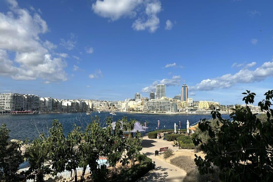 Blick auf die Stadt Valletta mit modernen Gebäuden und dem Hafen im Vordergrund.