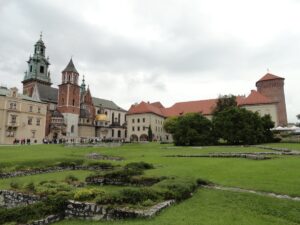Wawel Schloss in Krakau mit verschiedenen Gebäuden und grünen Rasenflächen im Vordergrund.