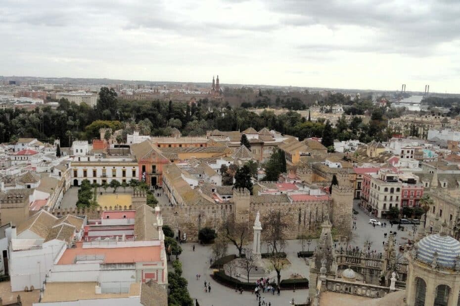 Luftaufnahme von Sevilla, die historische Gebäude und Dächer in der Stadt zeigt.