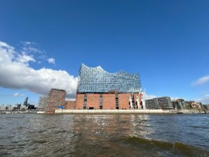 Die Elbphilharmonie in Hamburg mit ihrer markanten Architektur und dem Wasser im Vordergrund.
