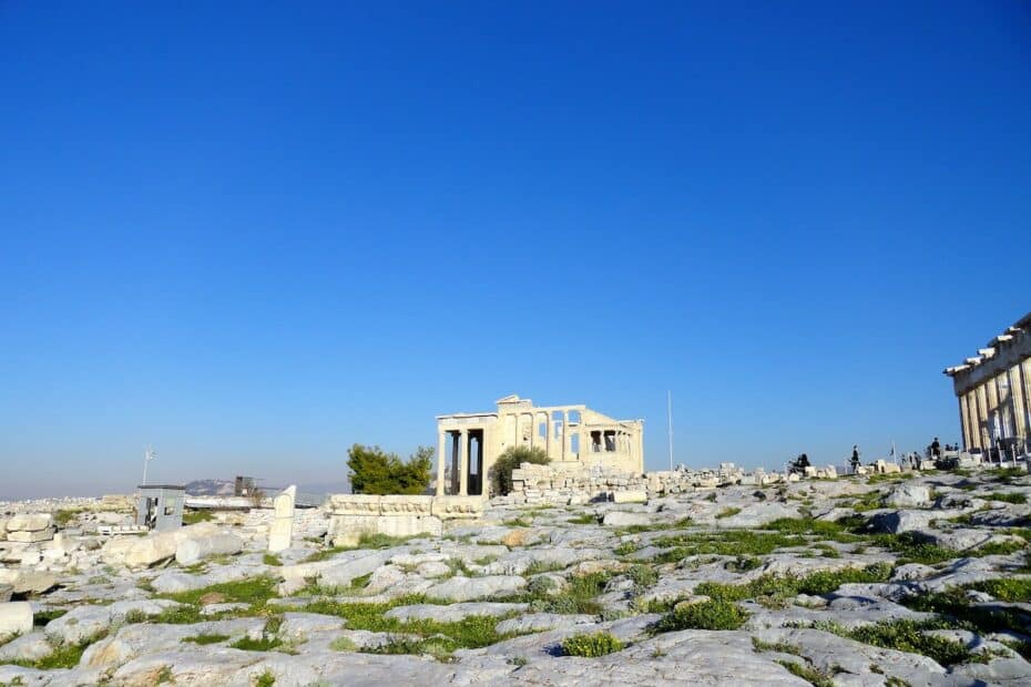 Ruinen der Akropolis mit Säulen und Steinen unter klarem blauen Himmel in Athen.
