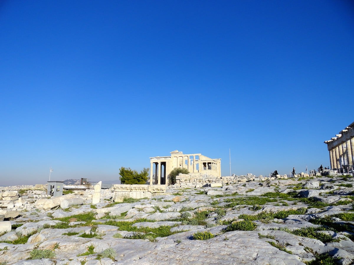Ruinen der Akropolis mit Säulen und Steinen unter klarem blauen Himmel in Athen.
