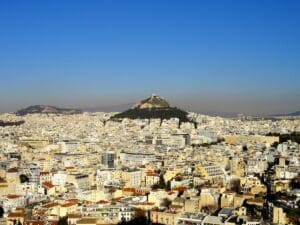 Blick auf die Stadt Athen mit der Akropolis im Hintergrund und einer klaren blauen Himmel.