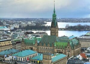 Das Hamburger Rathaus mit einer grünen Kuppel und umliegenden Gebäuden in der Stadt Hamburg.