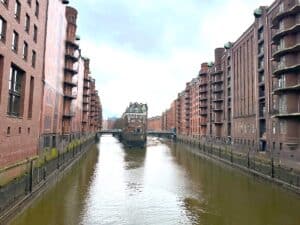 Blick auf die Speicherstadt in Hamburg mit Wasserkanal und Backsteingebäuden.