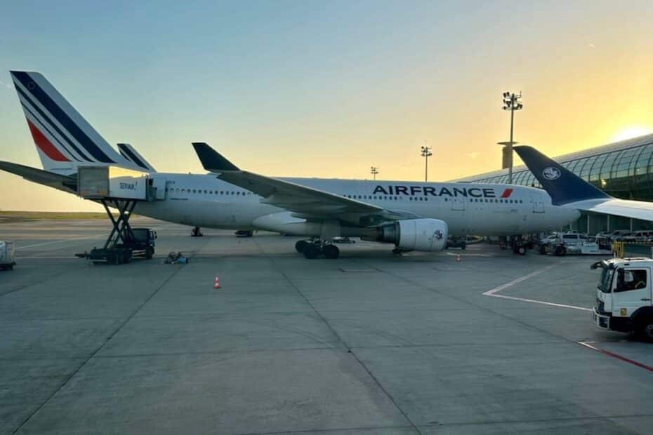 Ein Air France Flugzeug steht am Flughafen mit einem Gepäckwagen in der Nähe.