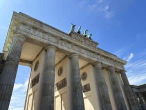 Das Brandenburger Tor in Berlin mit Säulen und einer Quadriga auf dem Dach unter blauem Himmel.