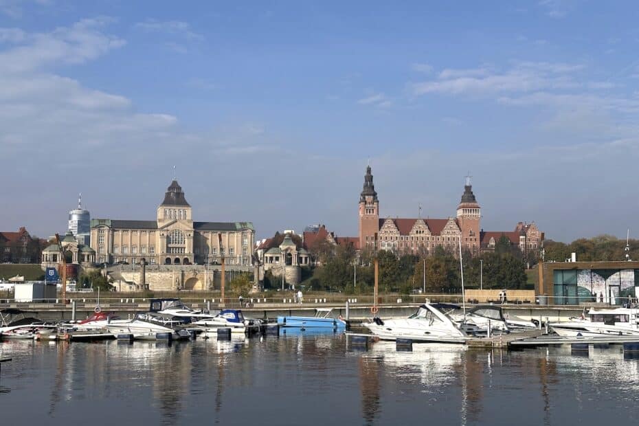 Hafen mit mehreren Booten und einer Stadtansicht mit historischen Gebäuden im Hintergrund.