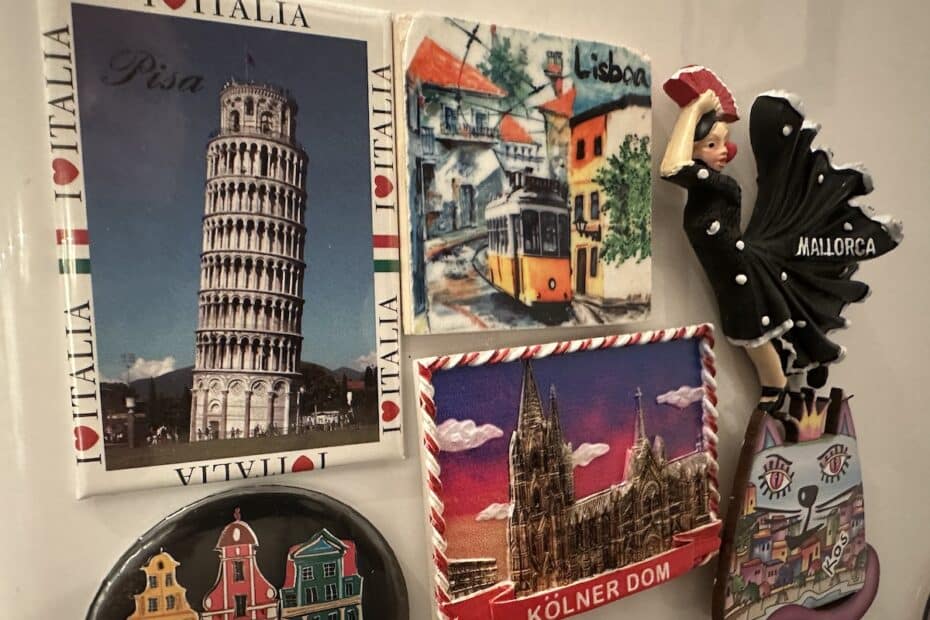 Magnetische Souvenirs mit Sehenswürdigkeiten aus Pisa, Köln, Mallorca und Lissabon auf einer Oberfläche.