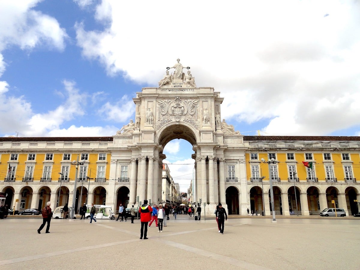 Der Arco da Rua Augusta, ein monumentales Tor in Lissabon, mit Menschen, die darunter hindurchgehen.