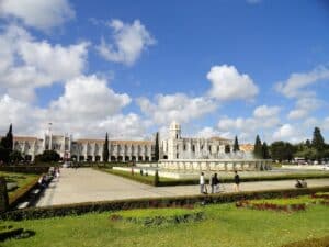 Das Kloster von Jerónimos in Lissabon mit einer großen Wasserfontäne im Vordergrund.