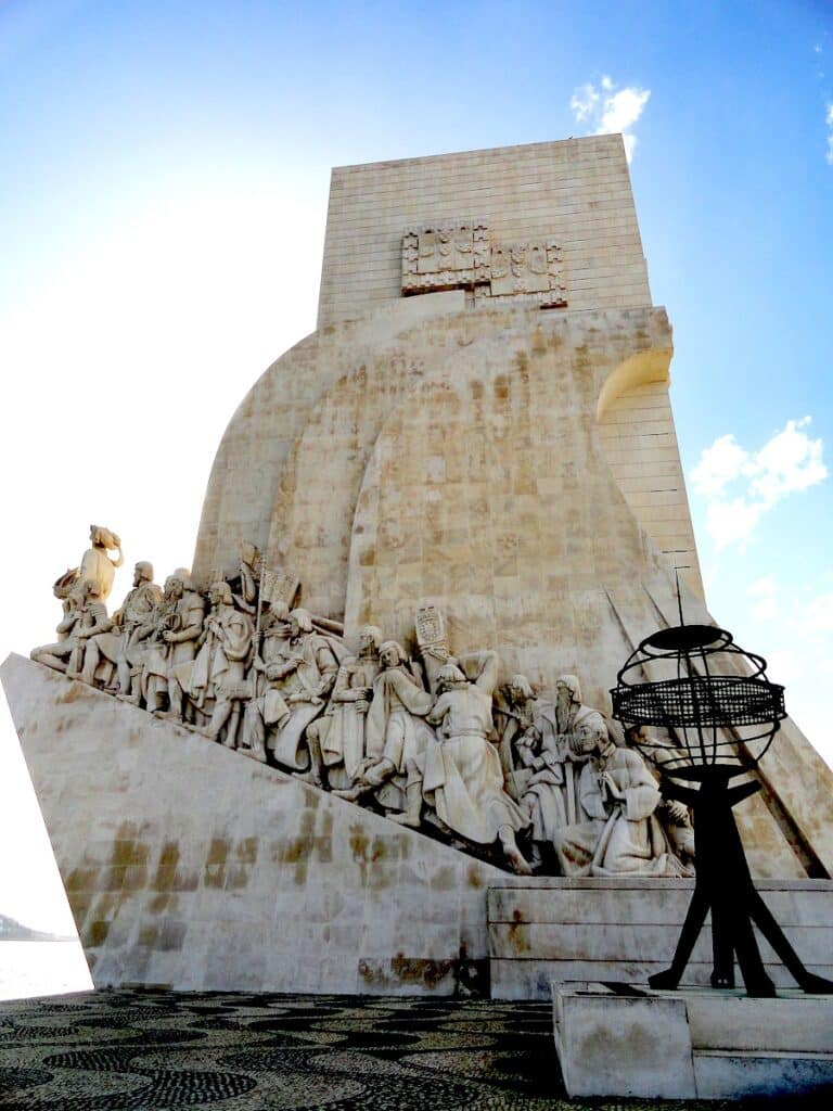 Das Monument der Entdeckungen in Lissabon mit Skulpturen von historischen Figuren und einer Weltkugel.