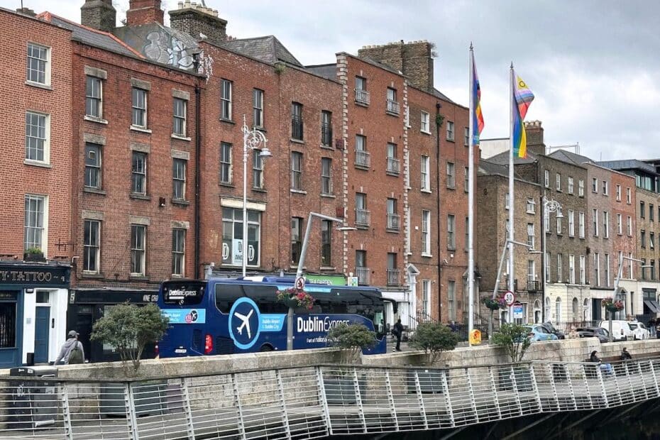 Dublin Express Bus auf einer Straße mit historischen Gebäuden im Hintergrund.