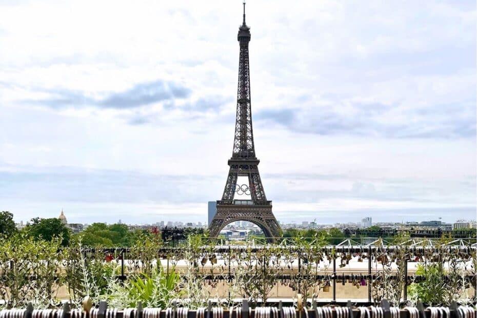 Eiffelturm in Paris, sichtbar vor einer grünen Landschaft und einem klaren Himmel.
