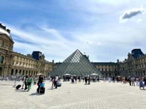 Glaspyramide des Louvre-Museums in Paris mit Besuchern im Vordergrund.