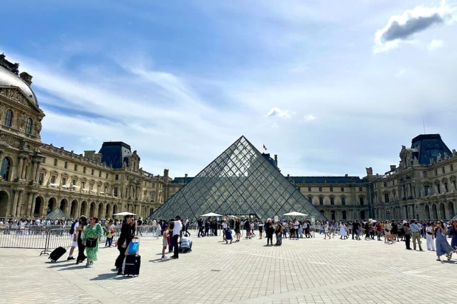 Glaspyramide des Louvre-Museums in Paris mit Besuchern im Vordergrund.