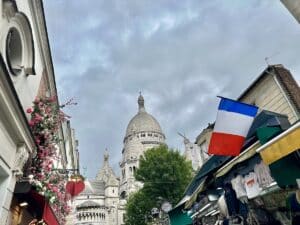 Basilika Sacré-Cœur mit einer französischen Flagge und Blumen in Montmartre, Paris.