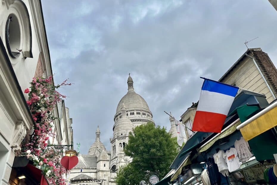Basilika Sacré-Cœur mit einer französischen Flagge und Blumen in Montmartre, Paris.