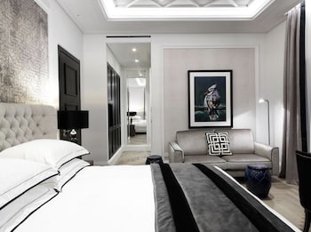 Modernes Hotelzimmer mit einem großen Bett, einem Sofa und Kunst an der Wand.