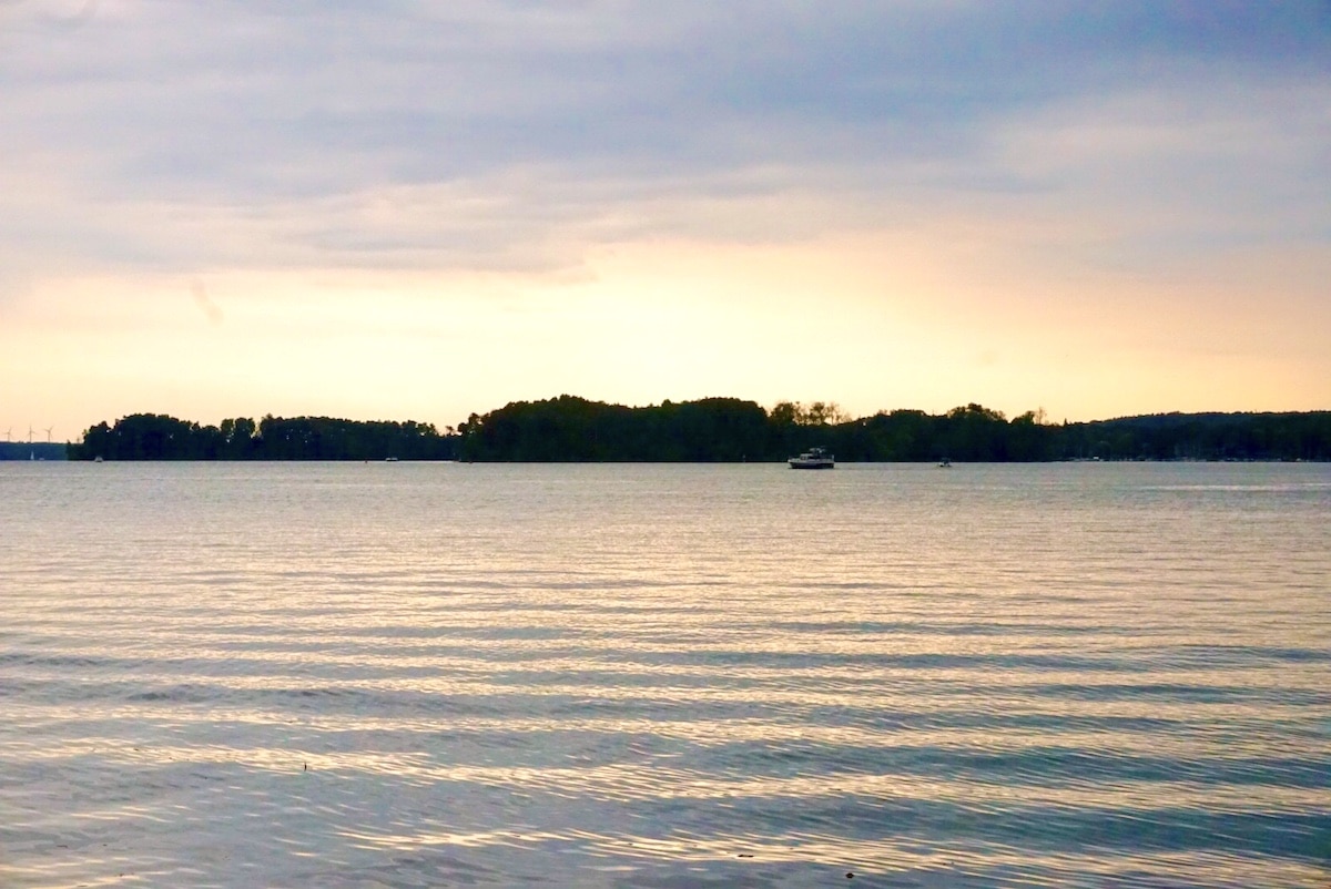 Ruhiger See mit sanften Wellen und einem bewölkten Himmel im Hintergrund.