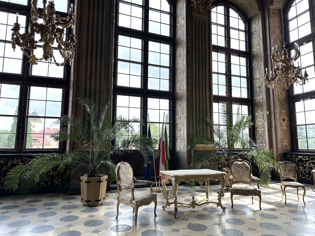 Elegantes Interieur mit einem Tisch und Stühlen sowie Pflanzen in einem großen Raum mit Fenstern.