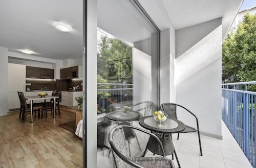 Moderne Wohnung mit Balkon, Essbereich und Stühlen im Apart-Hotel.