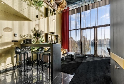 Moderne Wohnung mit einem kleinen Essbereich und großen Fenstern, die auf einen See blicken.