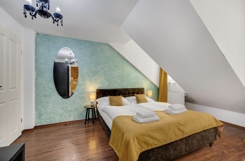 Schlafzimmer mit einem Doppelbett, einem Spiegel und zwei Nachttischen mit Lampen.