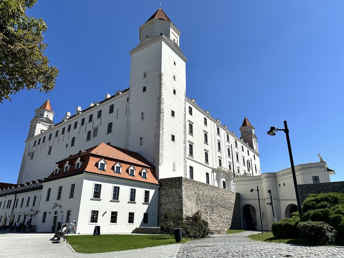 Blick auf die Bratislava Burg mit weißen Wänden und roten Dächern unter klarem Himmel.