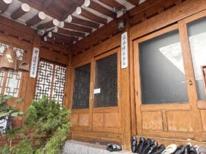 Eingang eines traditionellen koreanischen Hauses mit Holzverkleidung und dekorativen Elementen.