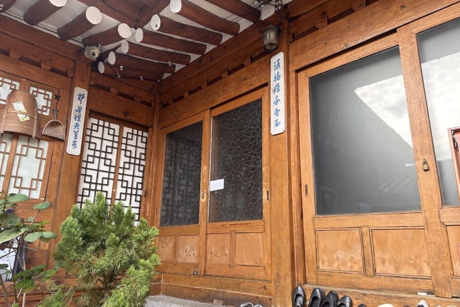 Eingang eines traditionellen koreanischen Hauses mit Holzverkleidung und dekorativen Elementen.