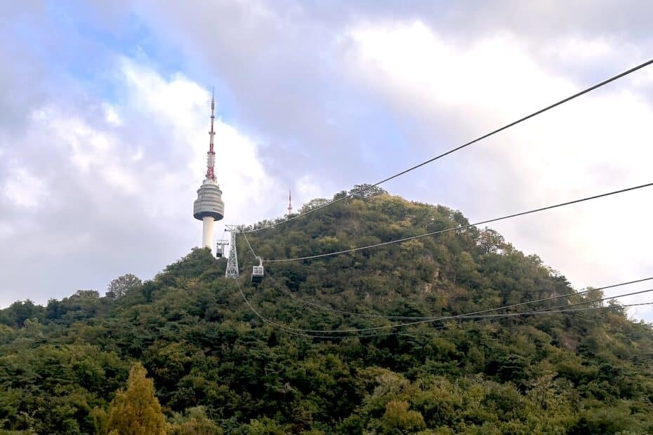 Namsan Seoul Tower auf dem Namsan-Berg mit Seilbahnen und bewaldeter Umgebung.