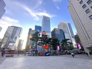 Stadtlandschaft mit modernen Wolkenkratzern und einem bunten Schriftzug 'I LOVE GANGNAM style'.