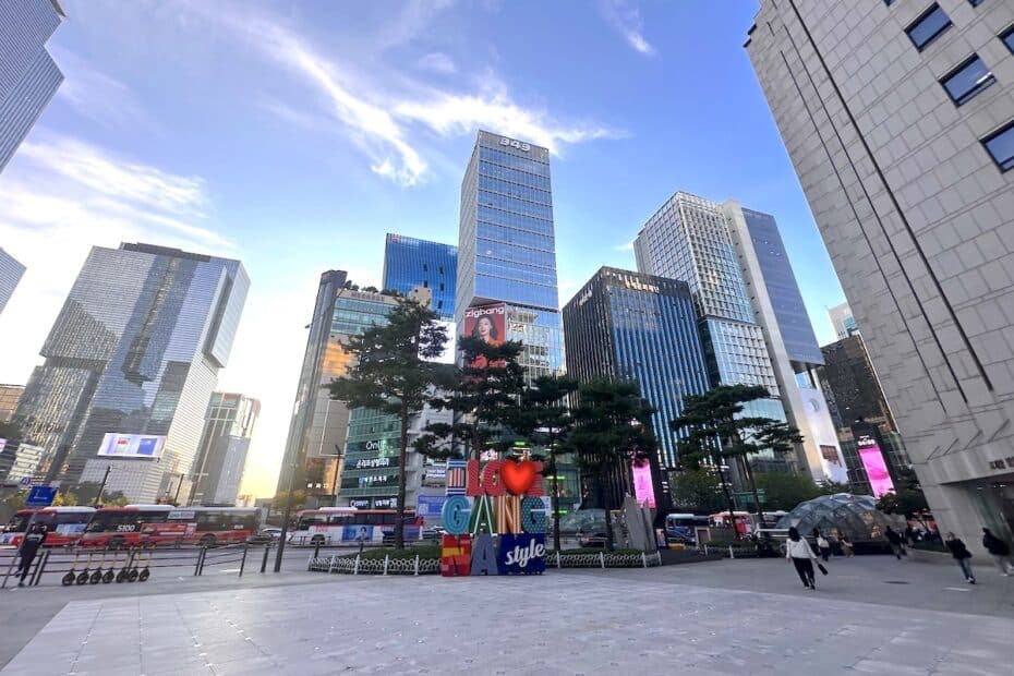 Stadtlandschaft mit modernen Wolkenkratzern und einem bunten Schriftzug 'I LOVE GANGNAM style'.