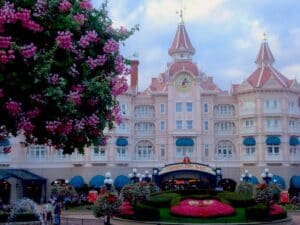 Das Disneyland Paris Hotel mit einer großen Uhr und bunten Blumenarrangements im Vordergrund.