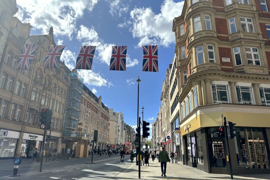 Straße mit mehreren britischen Flaggen, die über die Straße hängen, und Gebäuden im Hintergrund.