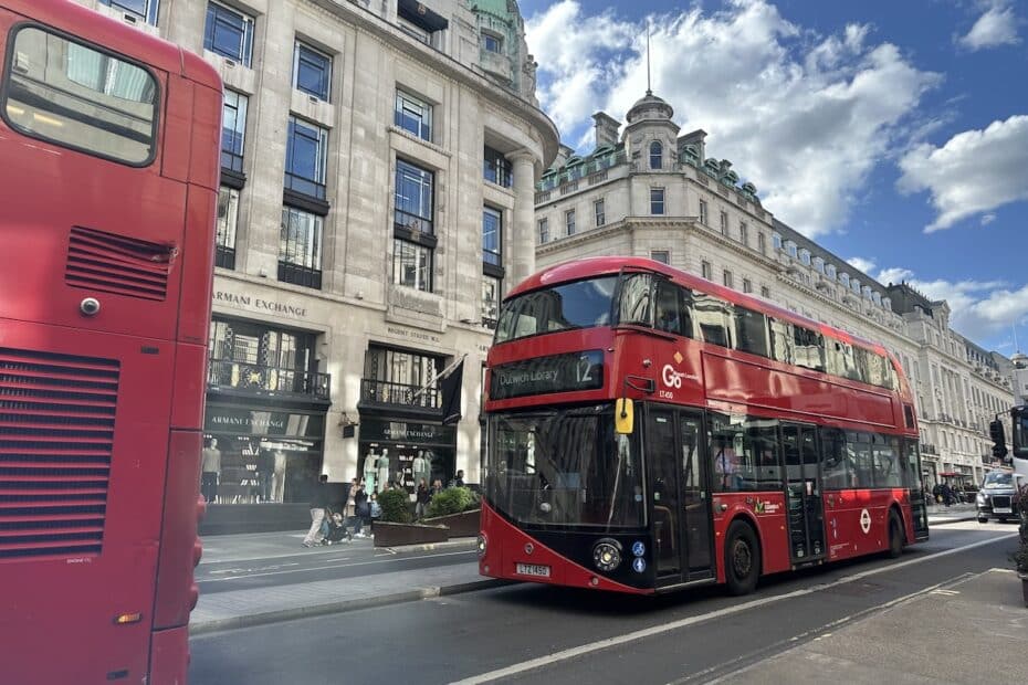 Roter Doppeldeckerbus der Linie 12 fährt auf einer Straße in London mit historischen Gebäuden im Hintergrund.
