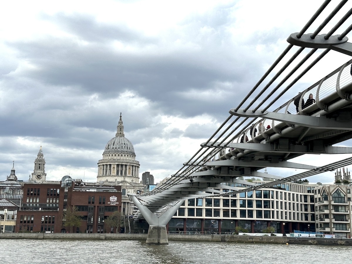 Millennium Bridge mit Blick auf die St. Paul's Cathedral und Wolken am Himmel über der Themse in London.