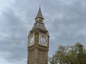 Der Elizabeth Tower mit der großen Uhr, bekannt als Big Ben, zeigt die Zeit an. Der Turm ist im neugotischen Stil erbaut.