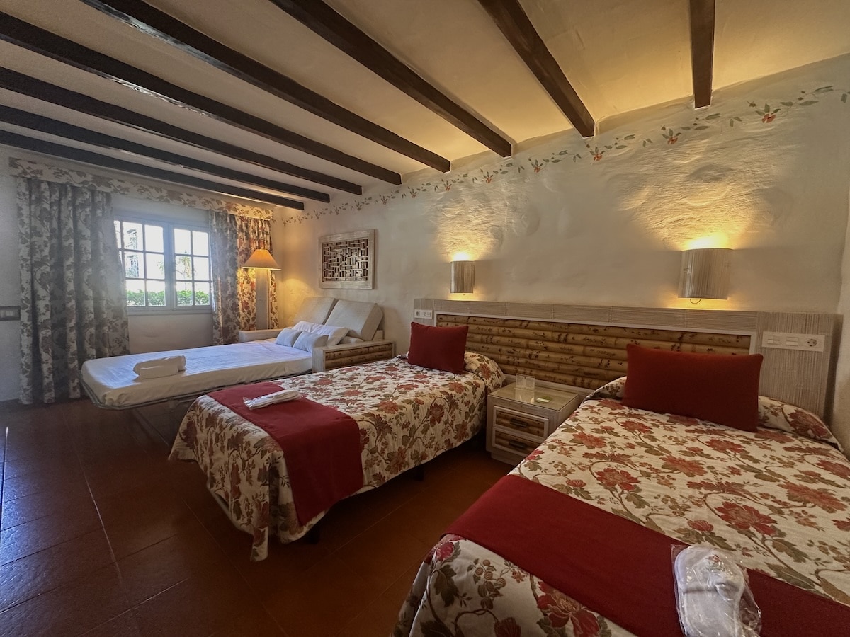 Hotelzimmer im Parque Tropical in Playa del Inglés, Gran Canaria: zwei Betten, warme Beleuchtung, Holzbalkendecke, florale Bettwäsche, ruhiges Gartenresort-Feeling.