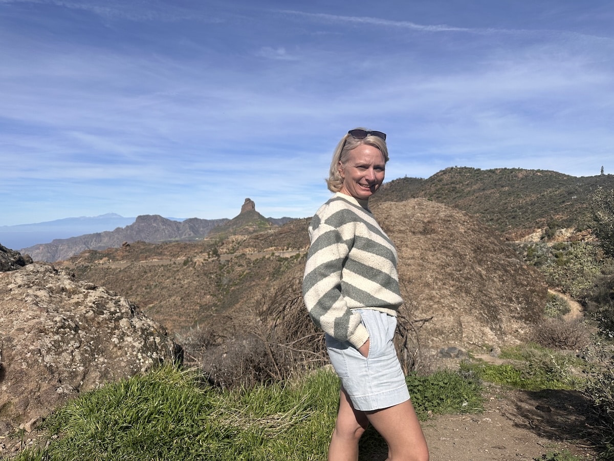 Person mit gestreiftem Pullover steht vor felsiger Landschaft und blauem Himmel auf Gran Canaria; Bezug zu Parque Tropical und Mandys Abenteuerwelt.