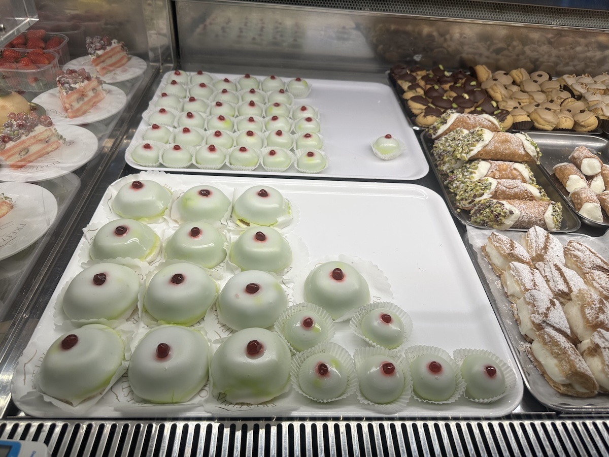 Zwischen weißen, mit Pistazie und Puderzucker bestäubten Cannoli-Spezialitäten und kleinen cremigen Desserts steht der süße Genuss im Fokus, Catania Streetfood.