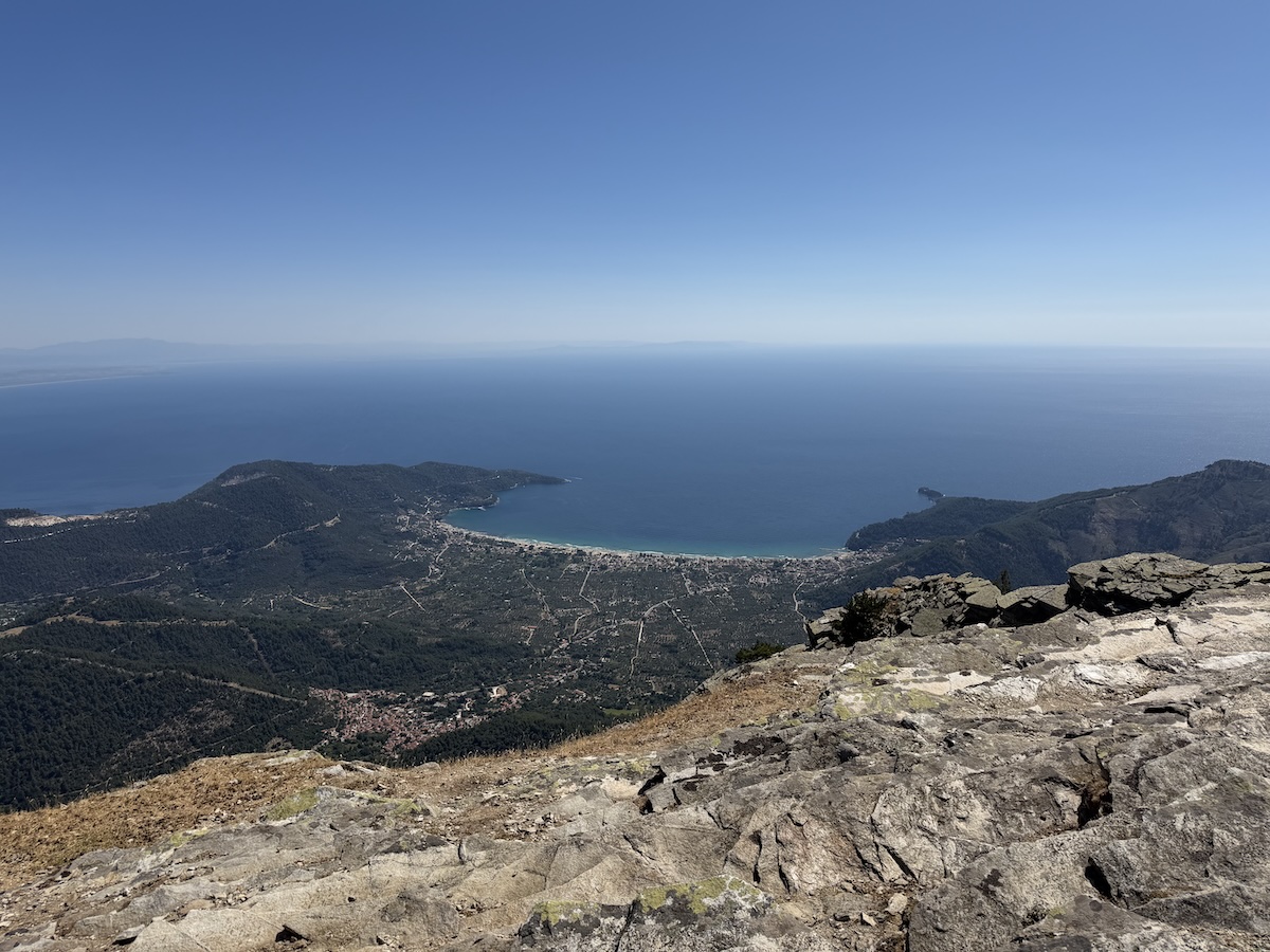 Felsiger Berggipfel mit weitem Blick auf die Küste von Thassos und das tiefblaue Meer bei der Suche nach Unterkünften